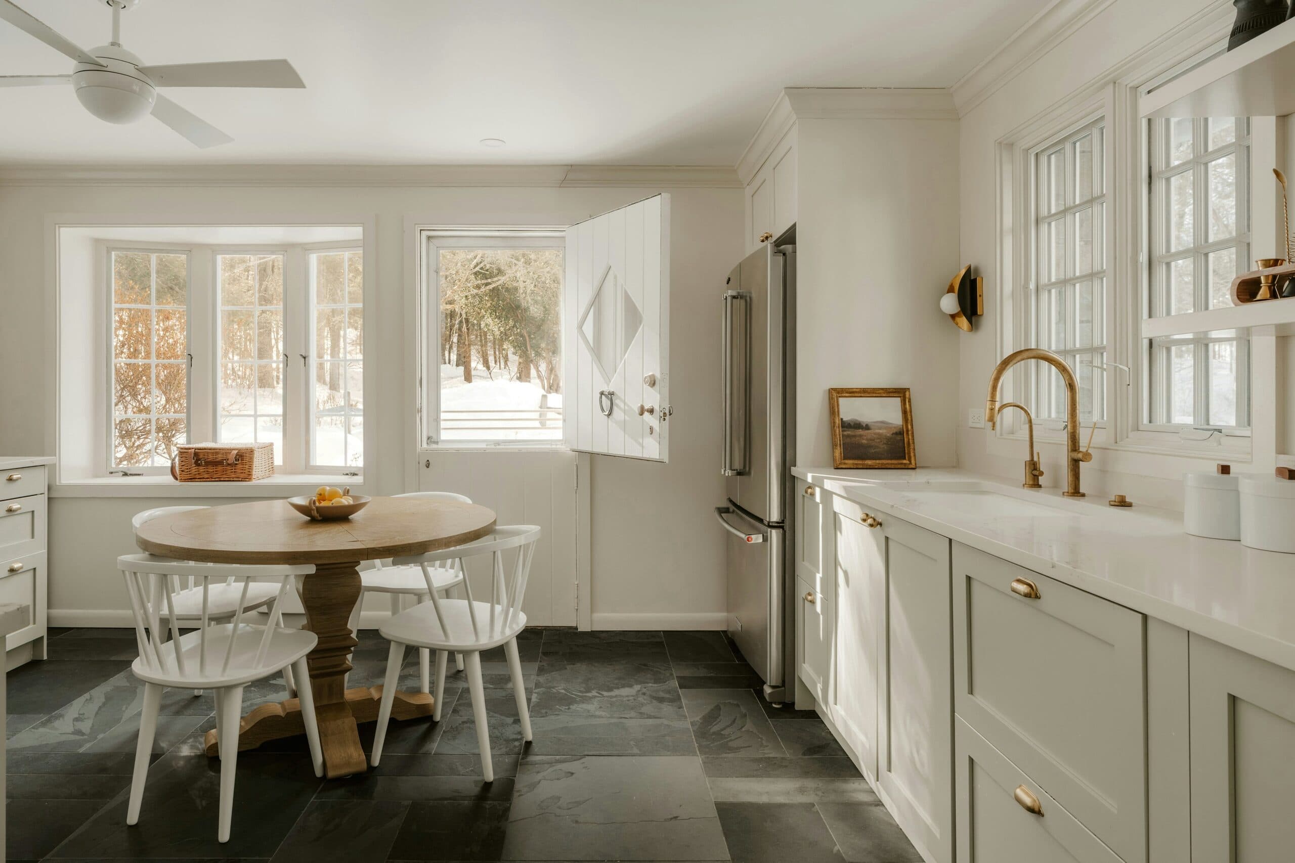 Open farmhouse kitchen and dining space with glass doors onto a bluestone terrace