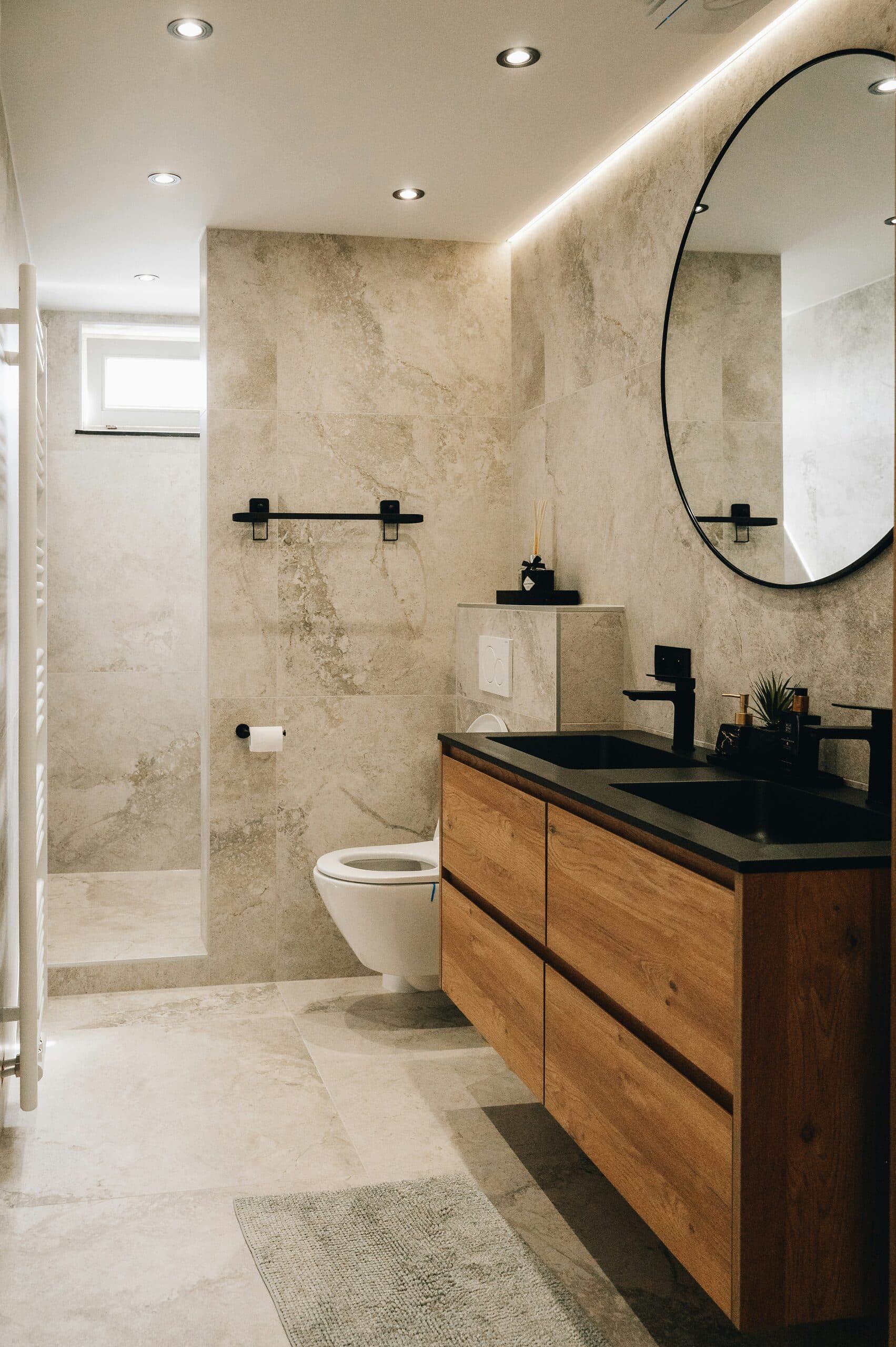 Spa-inspired primary bathroom with curbless stone shower and warm brass fixtures